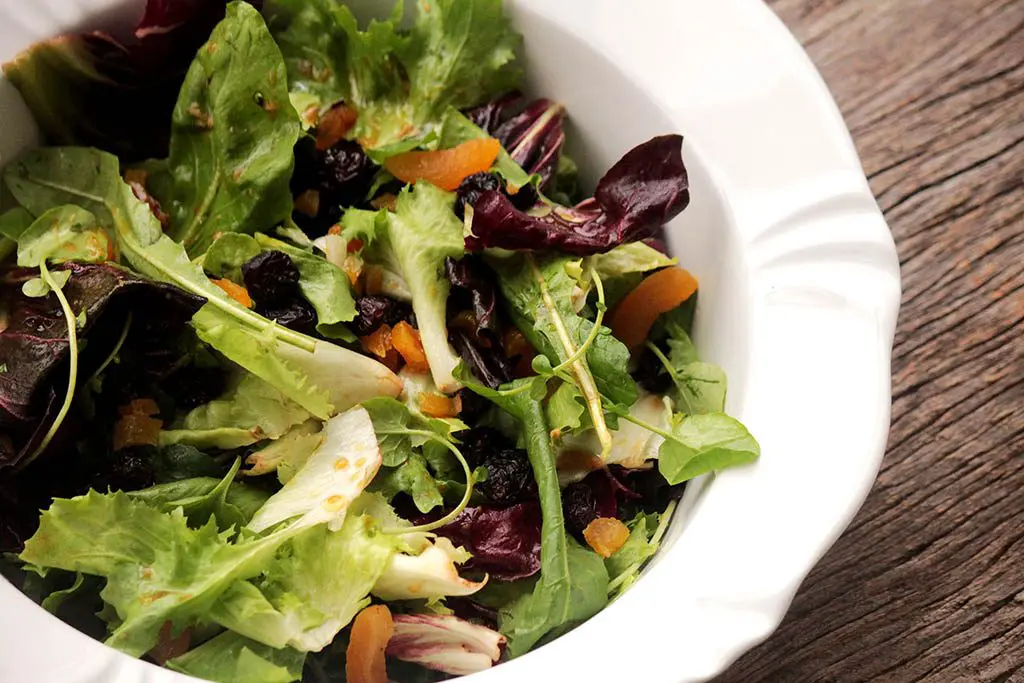 Salada de folhas com damascos, passas e molho de mostarda e mel