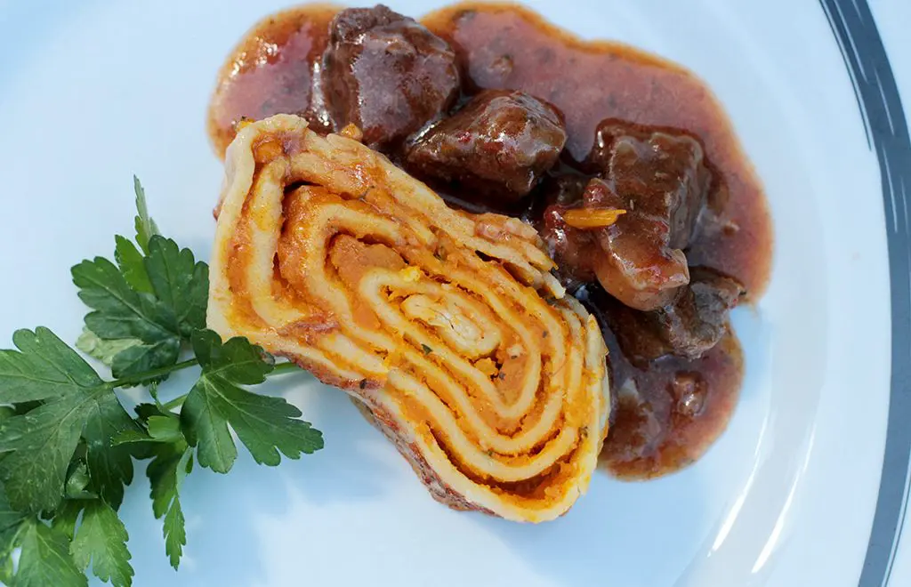 Tortéi enrolado cozido na carne de panela