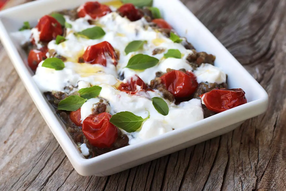 Berinjela com lentilha, tomate-cereja e iogurte