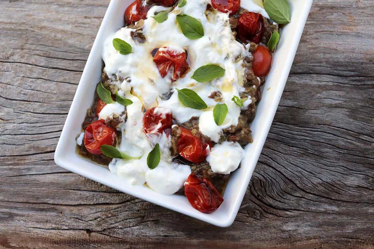 Berinjela com lentilha, tomate-cereja e iogurte